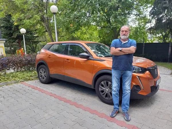 Klér Gábor, autós oktató az oktató autójával.