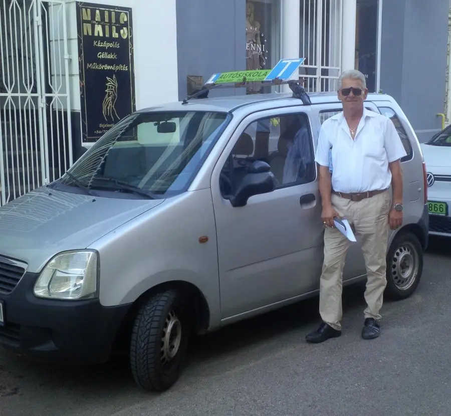 Nagy Sándor, autós oktató és iskolavezető az oktató autójával.